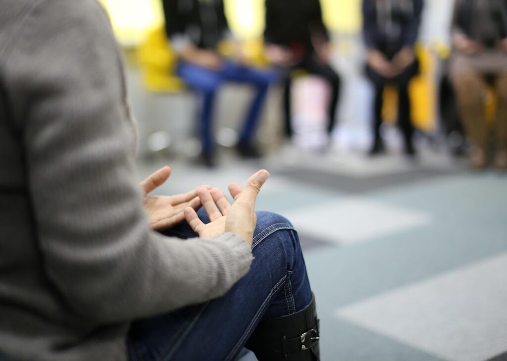 Personas sentadas en círculo durante un grupo de apoyo