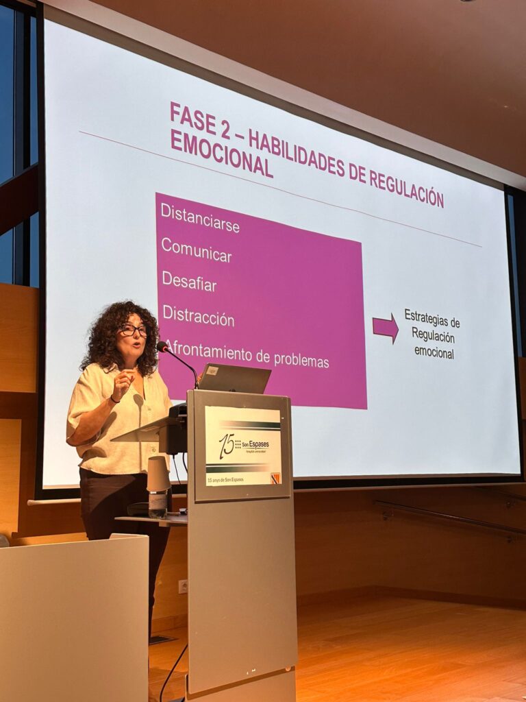Ponente en el atril durante una jornada, con una presentación sobre regulación emocional